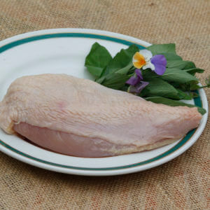 certified organic boneless chicken breast raw, on a white plate
